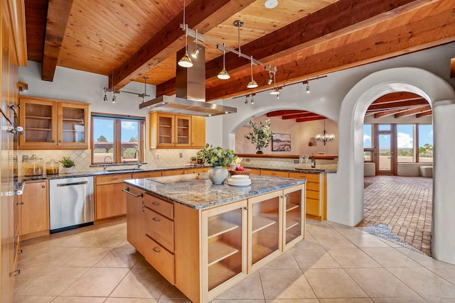 kitchen with stainless steel dishwasher, light tile patterned floors, arched walkways, beamed ceiling, and a kitchen island