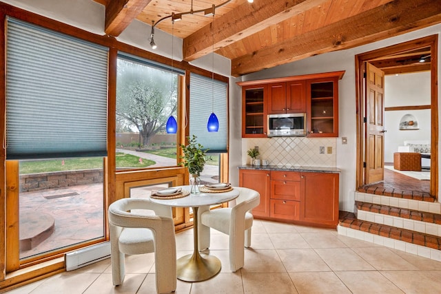 interior space featuring wooden ceiling, a wealth of natural light, light tile patterned flooring, and beamed ceiling