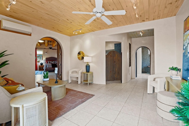 interior space featuring wooden ceiling, arched walkways, a wall unit AC, track lighting, and light tile patterned floors