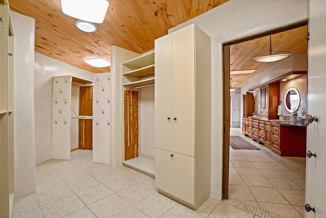 mudroom with wooden ceiling, light tile patterned flooring, and a sink