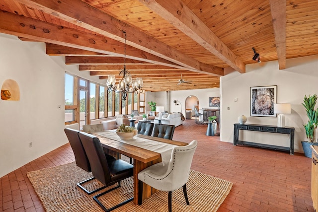 dining space featuring wood ceiling, an inviting chandelier, beamed ceiling, and brick floor