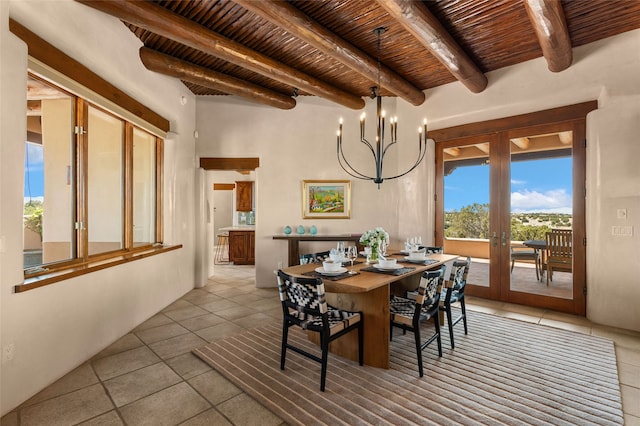 dining area featuring french doors, beam ceiling, a notable chandelier, wooden ceiling, and light tile patterned floors