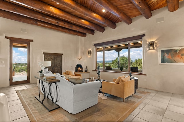 living area featuring light tile patterned floors, wood ceiling, a lit fireplace, beamed ceiling, and visible vents
