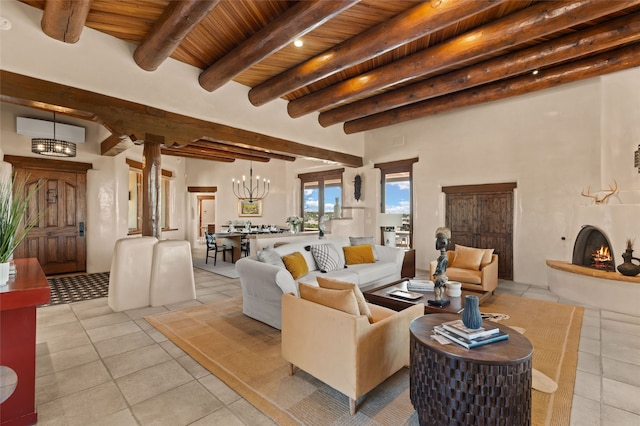 living room featuring light tile patterned flooring, an inviting chandelier, beamed ceiling, a warm lit fireplace, and wooden ceiling
