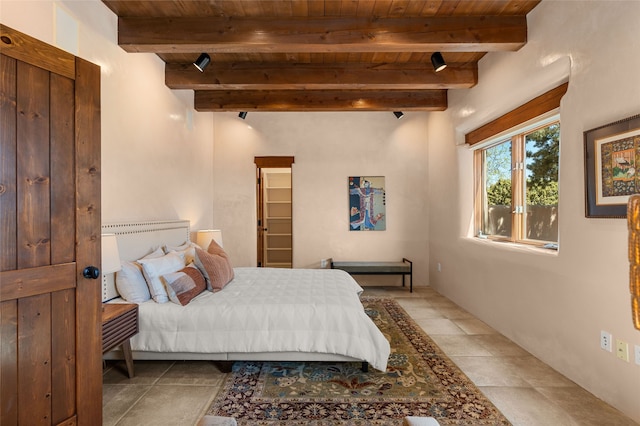 bedroom with wooden ceiling, beamed ceiling, and light tile patterned floors