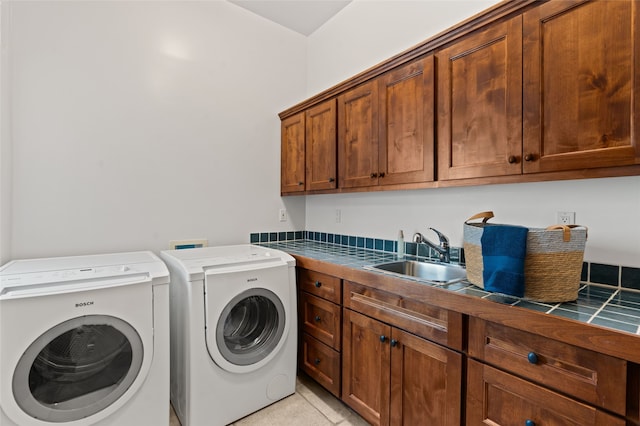 laundry room featuring washing machine and dryer, a sink, and cabinet space