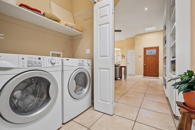 clothes washing area with washer and dryer, laundry area, light tile patterned floors, and built in shelves