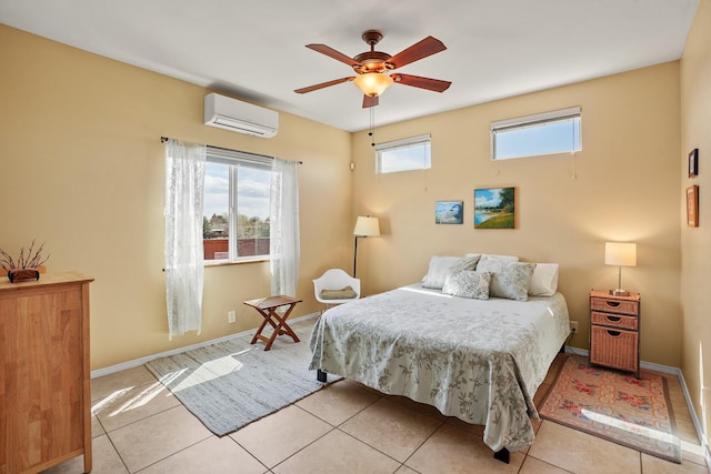 tiled bedroom featuring an AC wall unit, baseboards, and a ceiling fan