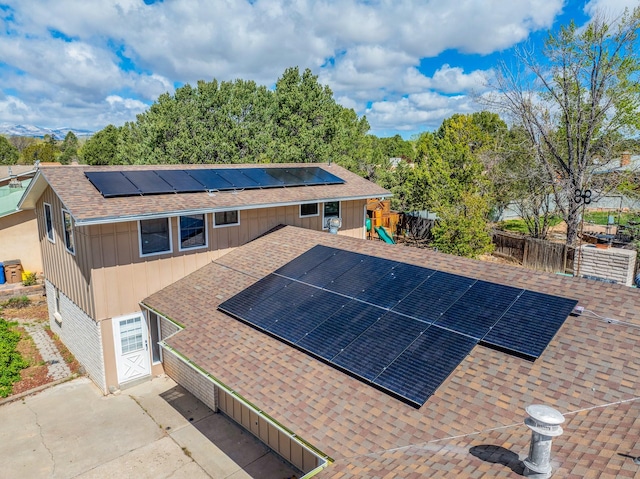 exterior space featuring solar panels, a playground, and fence