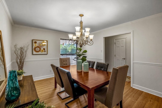 dining room featuring light wood-type flooring, baseboards, a chandelier, and crown molding