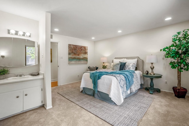 bedroom featuring recessed lighting, baseboards, light colored carpet, and a sink