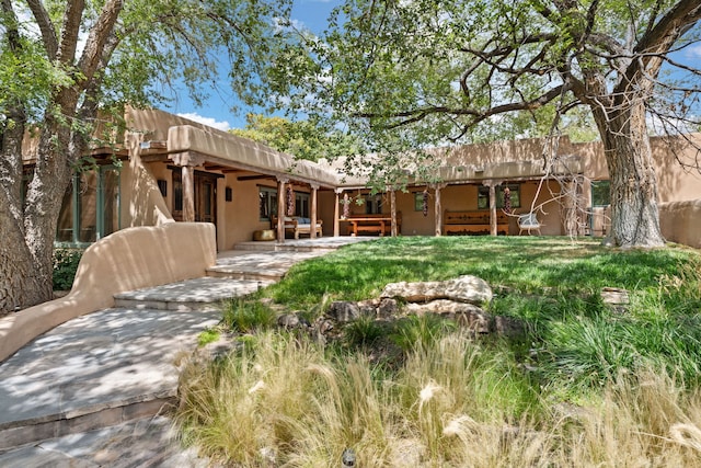 rear view of property with stucco siding and a patio area