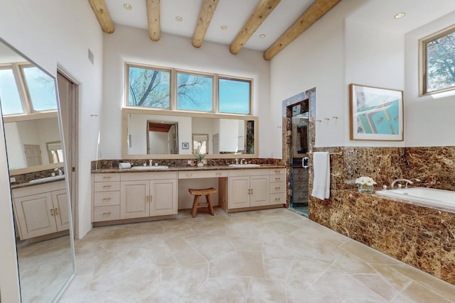 bathroom with a bath, vanity, beamed ceiling, a high ceiling, and recessed lighting