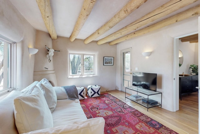 living area with beam ceiling and wood finished floors