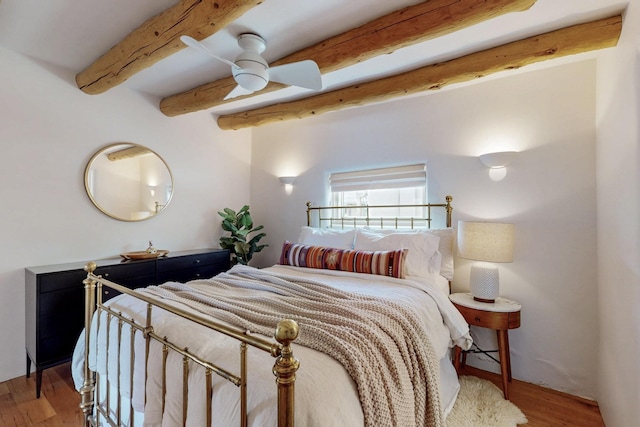 bedroom featuring beamed ceiling, wood finished floors, and ceiling fan