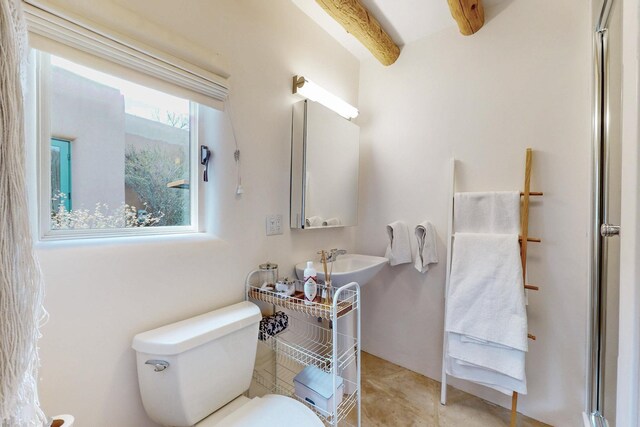 bathroom featuring tile patterned flooring, a sink, beam ceiling, and toilet