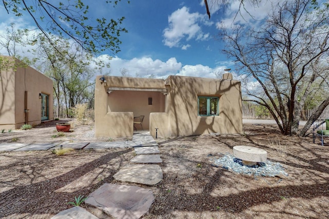 rear view of property featuring a chimney