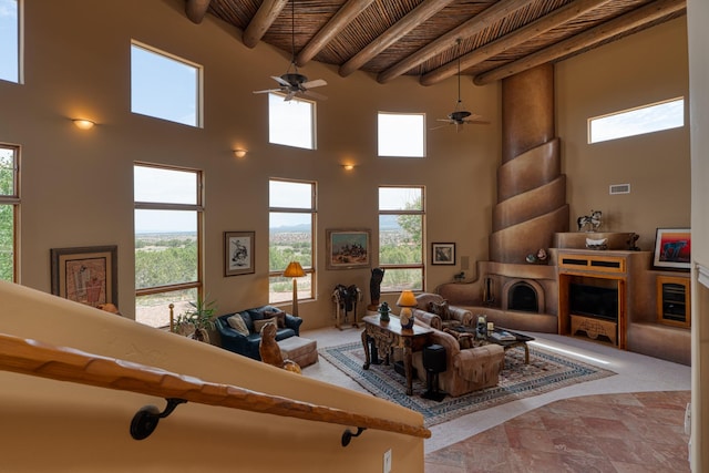 21 Canada Vista Dr, Sandia Park, NM 87047 - living room with a fireplace with raised hearth, beamed ceiling, a high ceiling, ceiling fan, and wood ceiling