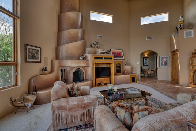 21 Canada Vista Dr, Sandia Park, NM 87047 - living room with arched walkways, visible vents, a towering ceiling, and a healthy amount of sunlight