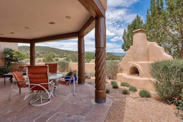 21 Canada Vista Dr, Sandia Park, NM 87047 - view of patio with an outdoor fireplace, outdoor dining area, and a mountain view