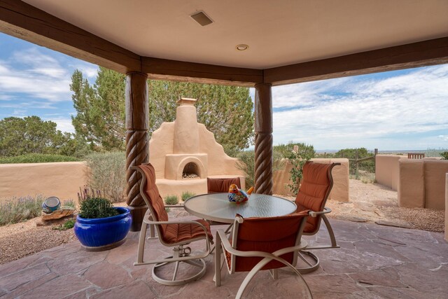 21 Canada Vista Dr, Sandia Park, NM 87047 - view of patio with fence, exterior fireplace, and outdoor dining space