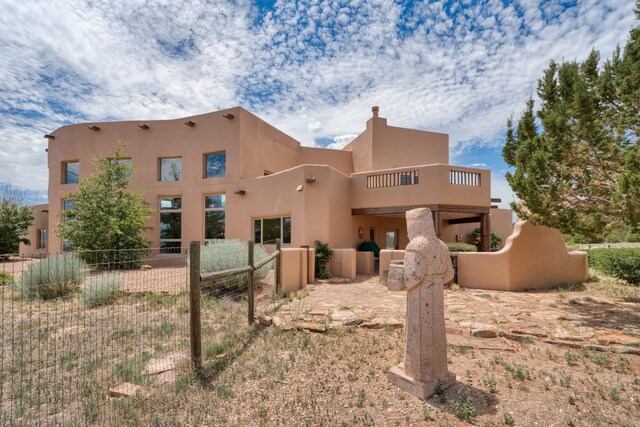 21 Canada Vista Dr, Sandia Park, NM 87047 - back of property with fence, a balcony, and stucco siding