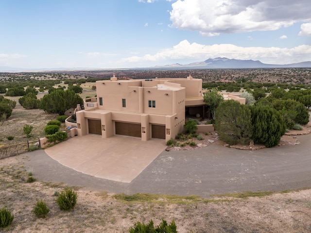 21 Canada Vista Dr, Sandia Park, NM 87047 - view of front facade with fence, stucco siding, an attached garage, driveway, and a mountain view