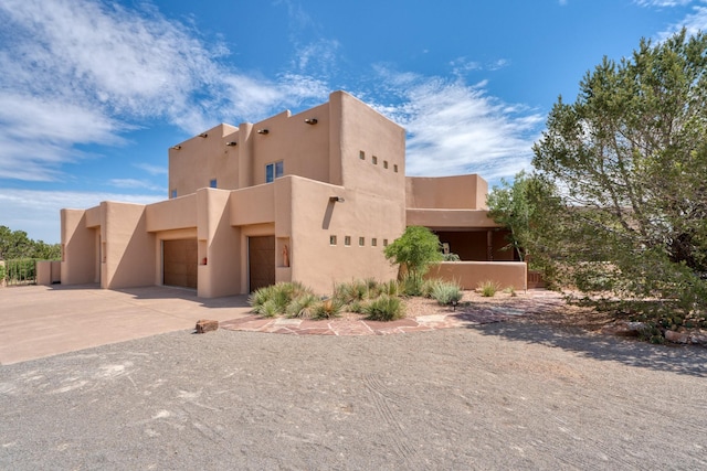 21 Canada Vista Dr, Sandia Park, NM 87047 - view of front facade with stucco siding, driveway, and a garage