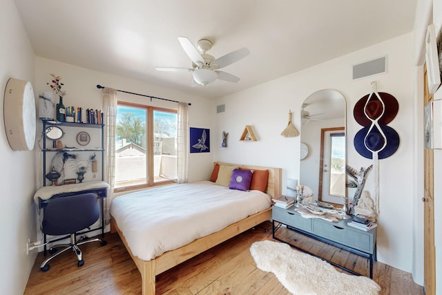 bedroom with visible vents, a ceiling fan, and wood finished floors