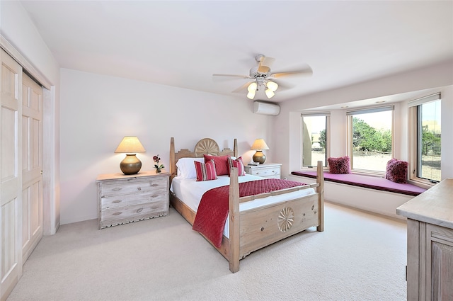 bedroom featuring light colored carpet, ceiling fan, a wall mounted air conditioner, and a closet