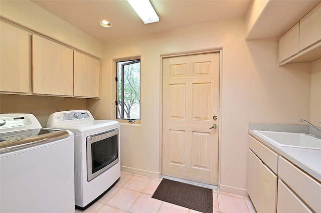 laundry area with washer and dryer, cabinet space, a sink, and light tile patterned floors