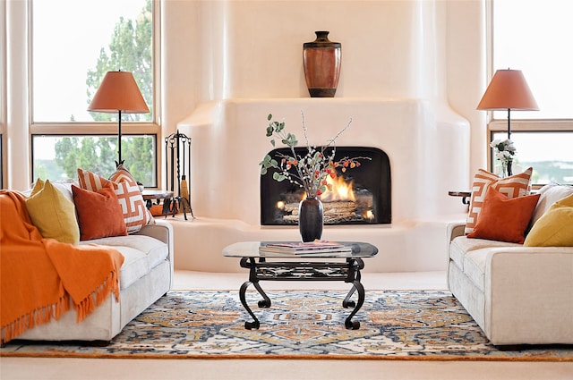 living area with plenty of natural light and a lit fireplace