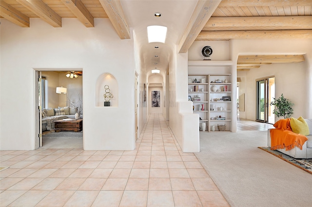 hallway featuring built in shelves, wooden ceiling, beam ceiling, and light tile patterned floors