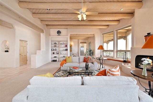 carpeted living area featuring wood ceiling, a ceiling fan, beam ceiling, and tile patterned flooring