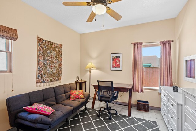 tiled home office featuring a wealth of natural light, a ceiling fan, and baseboards