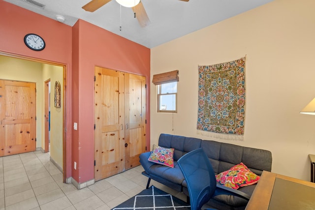 living area with visible vents, baseboards, ceiling fan, and light tile patterned floors