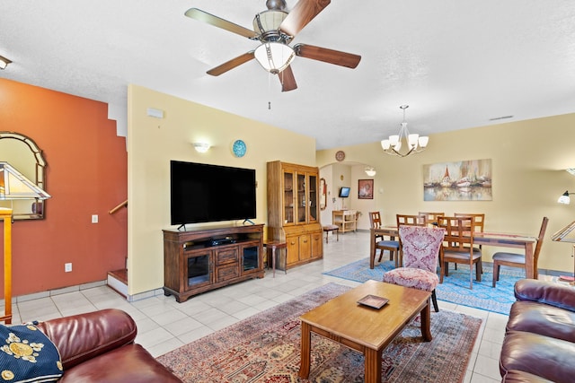 living area featuring ceiling fan with notable chandelier, baseboards, and light tile patterned floors
