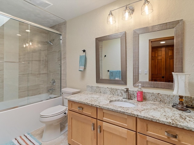 full bath featuring visible vents, a textured wall, vanity, and toilet