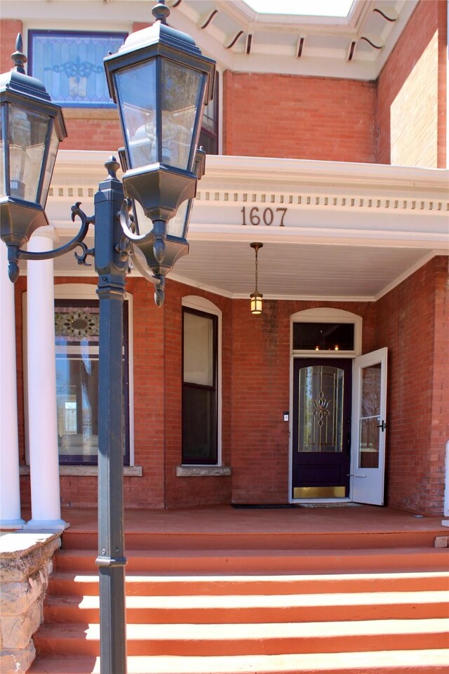 1607 8th St, Las Vegas, NM 87701 - view of exterior entry featuring brick siding and covered porch