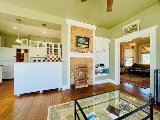 1607 8th St, Las Vegas, NM 87701 - living area featuring baseboards, a fireplace, dark wood-type flooring, and ceiling fan