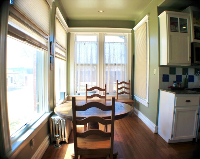 1607 8th St, Las Vegas, NM 87701 - dining area with baseboards, radiator heating unit, dark wood-style floors, and recessed lighting