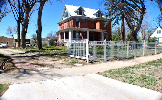 1607 8th St, Las Vegas, NM 87701 - victorian house with a gate, a porch, and a fenced front yard
