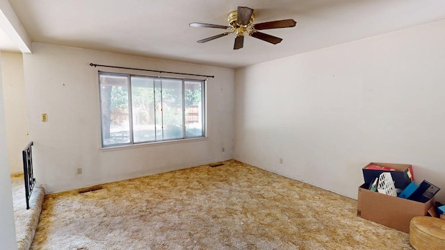 carpeted spare room with ceiling fan and visible vents