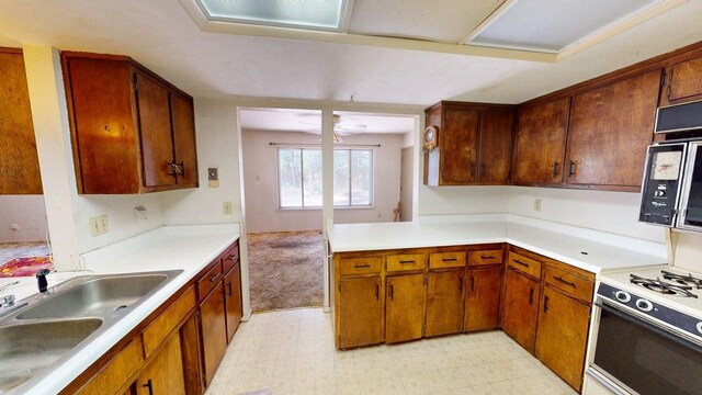 kitchen featuring brown cabinetry, a sink, and light countertops
