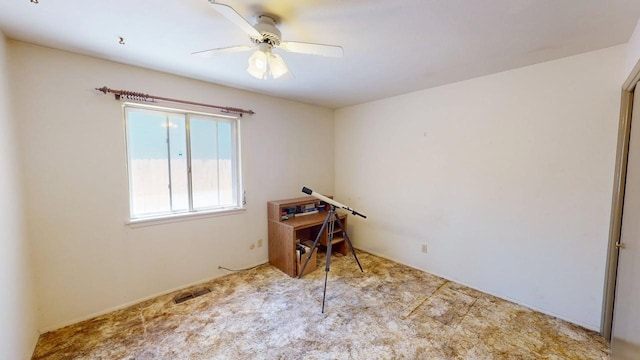 home office with a ceiling fan, carpet flooring, and visible vents