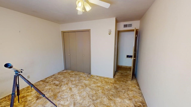 unfurnished bedroom featuring a ceiling fan, carpet flooring, visible vents, and a closet