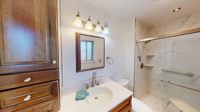 full bath featuring a marble finish shower, vanity, and toilet