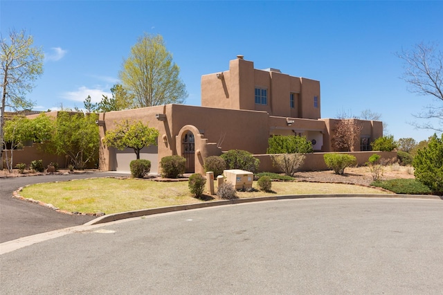 exterior space with an attached garage, aphalt driveway, fence, and stucco siding
