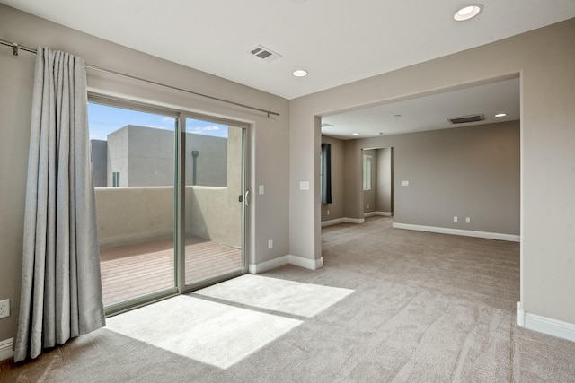 empty room featuring visible vents, recessed lighting, carpet flooring, and baseboards