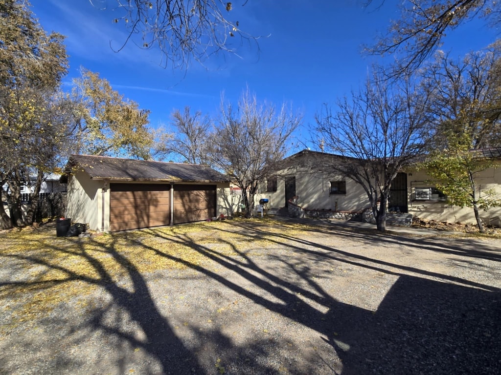 view of side of home featuring a garage, an outdoor structure, and driveway